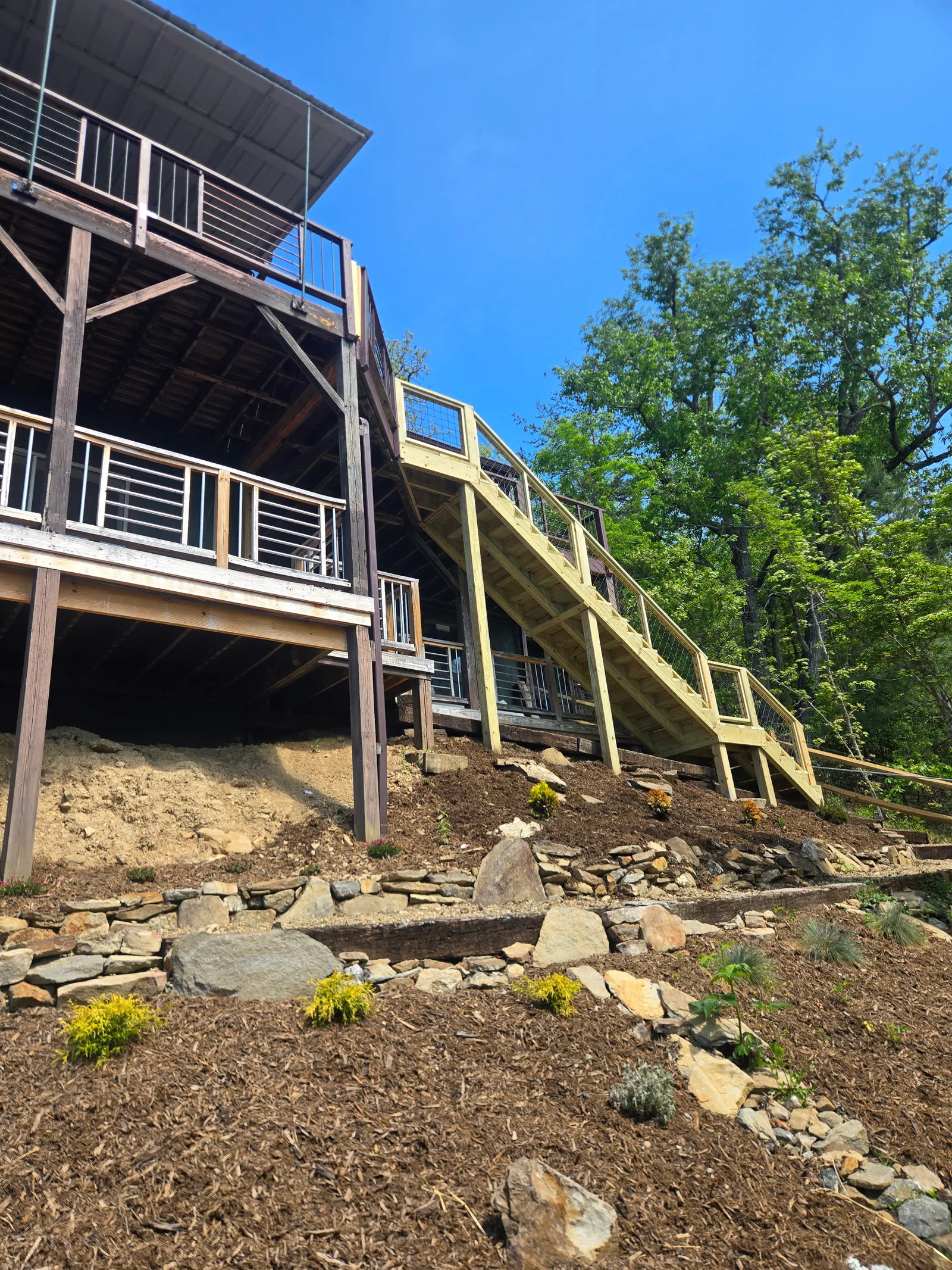 Full exterior staircase run connecting a sloped yard to an upper deck